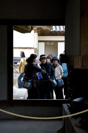 일본인 관광객이 가이드의 설명을 듣고 있다. 전통가옥의 부엌.