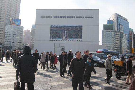 숭례문 복원 공사 현장을 지나는 사람들과 숭례문 사진이 붙어 있는 가림막.
