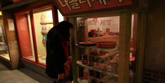 관람객이 당시 빵집 전시물를 관람하고 있다.